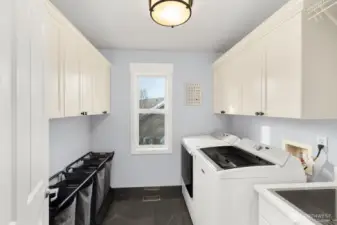 Upstairs laundry with storage and utility sink.