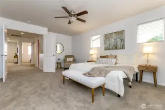 Spacious primary bedroom with wide hall entry and French doors. Ceiling fan with remote and spacious enough for a sitting area.