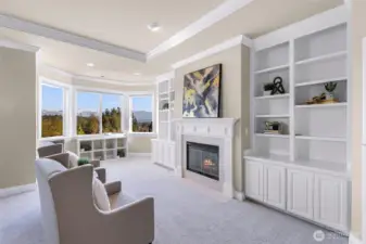 Primary bedroom with fireplace, seating area and great view of the Cascades and Mt. Si.