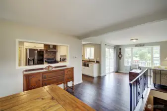 Open concept living room, dining room, kitchen.  Black wrought iron railings around the staircase.