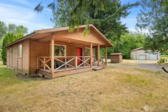 This cedar cabin is charming, inside and out! The sitting porch is so inviting! There is a pump house with storage and the 30 x 30 metal shop beyond.