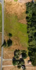 Looking down at the property with the three pastures with run-in sheds and paddocks.