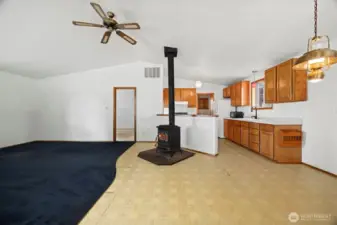 Inside you will find an open floor plan with vaulted ceilings and a fan to circulate the heat from the freestanding wood stove. The flooring does need to be replaced.