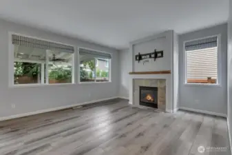 Light and bright family room with cozy fireplace and custom shades