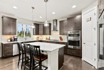 Elevate your culinary journey in this stunning gourmet kitchen, where stainless steel double ovens meet sleek quartz counters to redefine the art of cooking.