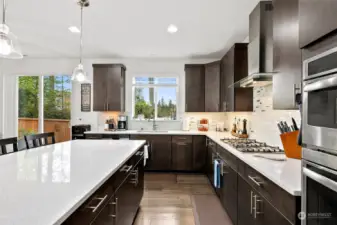 Prepare to be captivated by the centerpiece of this kitchen: a sprawling quartz counter island, adorned with ample seating and complemented by an on-trend backsplash that exudes modern elegance.