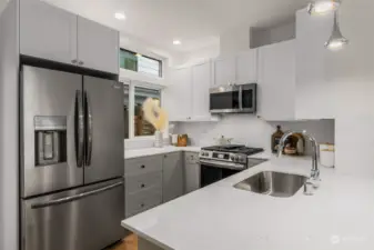 This contemporary kitchen enhances the hosting experience, featuring a window that invites abundant natural light.