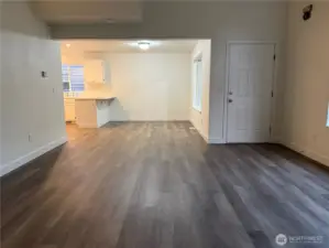 Living room area into kitchen, front door access