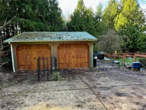 Detached 24 x 28 garage with custom doors and metal roofing.