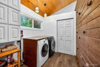 Laundry room with closet and a custom rock climbing wall to a private loft area above