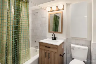 Updated bathroom with new tile, vanity and fixtures.