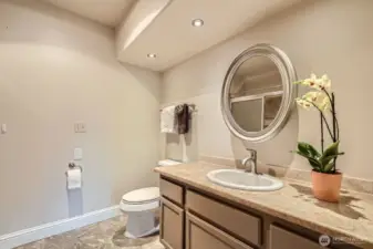 Large full bath off the primary bedroom with laminate tile floors.