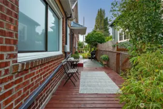 and an adjacent deck which leads to the back yard creates a wonderful space for sitting and enjoying coffee,  beers, or lemonade, and conversations with friends and family