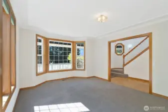 Versatile front room with charming bay windows and soft carpeting, ideal for a formal living space, reading nook, or sunlit retreat.