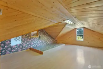 Unique bonus room with vaulted tongue-and-groove wood ceilings and walls, laminate flooring, and a custom tiled platform. Great for a studio, guest space, or creative retreat.