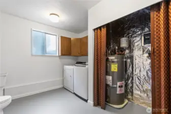 Downstairs laundry room with toilet and utility sink