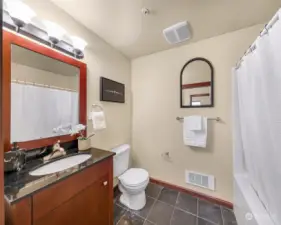 The guest bathroom features slate floors and a tub/shower.