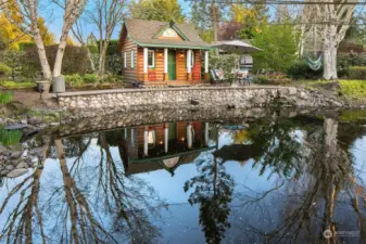 Fenced Koi pond with the cutest playhouse!