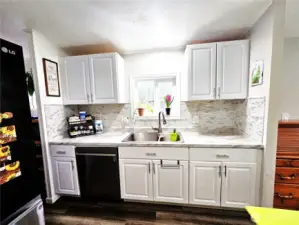 Bright Kitchen with glass tile backsplash.