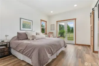 Retreat to the serene primary suite with barn doors, wide plank flooring, a walk-in closet and spa like primary bath.