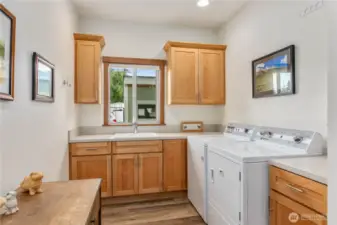 This fantastic laundry room is both functional and private, with a door to separate it from the main living area. Features include extra cabinetry, a dedicated sink, and a closet for added storage