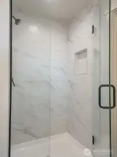 Primary Shower with floor to ceiling tile.
