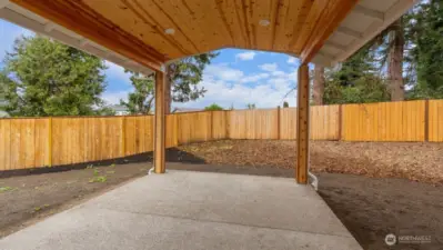 Covered patio has beautiful wood accents and lighting.