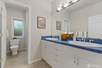 Full size bath with double sinks and a separate tub/shower and WC area.