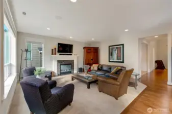 Another angle of the main living area shows the perfect blend of openness and warmth. Plush carpeting meets rich hardwood floors, and the fireplace anchors the space while connecting to the rest of the home’s flowing layout.