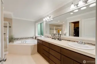 Luxurious five-piece ensuite bath with dual sinks, an oversized vanity, soaking tub, and walk-in shower. Modern tile details and warm cabinetry combine elegance with everyday functionality.