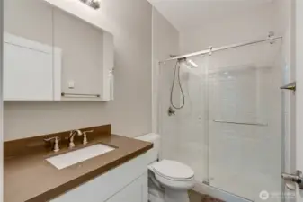 Stylish full bathroom with quartz countertop, subway tile shower surround, and modern fixtures. Designed with a clean, timeless look and located conveniently near the lower bedroom and living area.