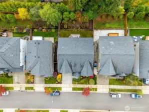 Top-down aerial image outlining the property’s lot and fenced backyard. Highlights proximity to greenbelt space and neighboring homes for context and scale.