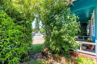 The side yard off the front porch is private and feels almost like a "secret garden" with how the shrubs conceal this area yet sunshine flows through