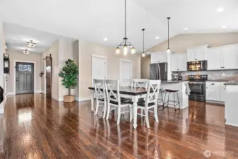 Hand scraped hardwood flooring throughout living area adds warmth to color scheme