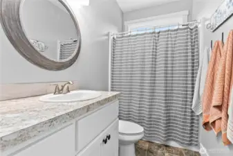 Full size bathroom between bedrooms with extra storage behind door
