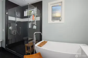 A large walk-in shower with tile surround and frameless glass