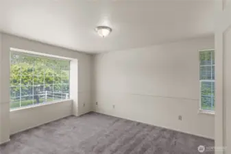 The main level in Unit A also includes this spacious primary suite with two closets and full bath. The big windows bring in the private, wooded view.