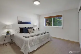 Primary Bedroom, looking out to the eastern lawn and evergreen trees beyond.