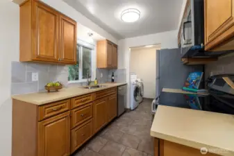 The kitchen has stainless steel appliances, tile backsplash and the laundry room is conveniently located with extra storage.