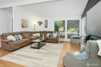 Bright and welcoming living room with vaulted ceilings and peaceful garden views.