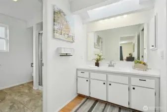 Bright ensuite bath with skylight and walk-in shower.