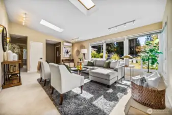 The living area is filled with natural light that streams in from the wall of windows and skylights.