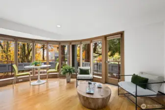 Family room next to the kitchen with a wrap around deck and views over Madrona Woods.