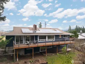 Looking at the rear elevation of the home and decks with the solar panels.