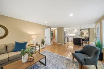 The open-concept family room also enjoys hardwood flooring. The utility room is through the white door to the left.