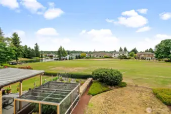 Private patio view of 4th Fairway and Lake Tapps; clouds are hiding the full view of Mount Rainier.
