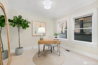 The main floor bedroom is tucked away from the living spaces. Currently staged as an office, but easily accommodates a queen bed.
