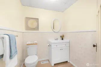 Half bath on the main floor has a new vanity, flooring, and newer toilet. Some extra space to potentially add a walk-in shower.