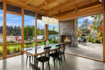 The west wall of the dining/great room opens to a stone patio featuring a second steel-and-concrete fireplace—perfect for outdoor entertaining!