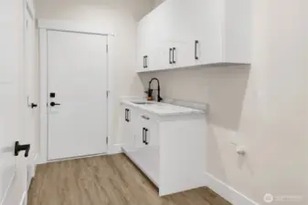 Conveniently Located Laundry Room With Sink and Plenty of Storage Space